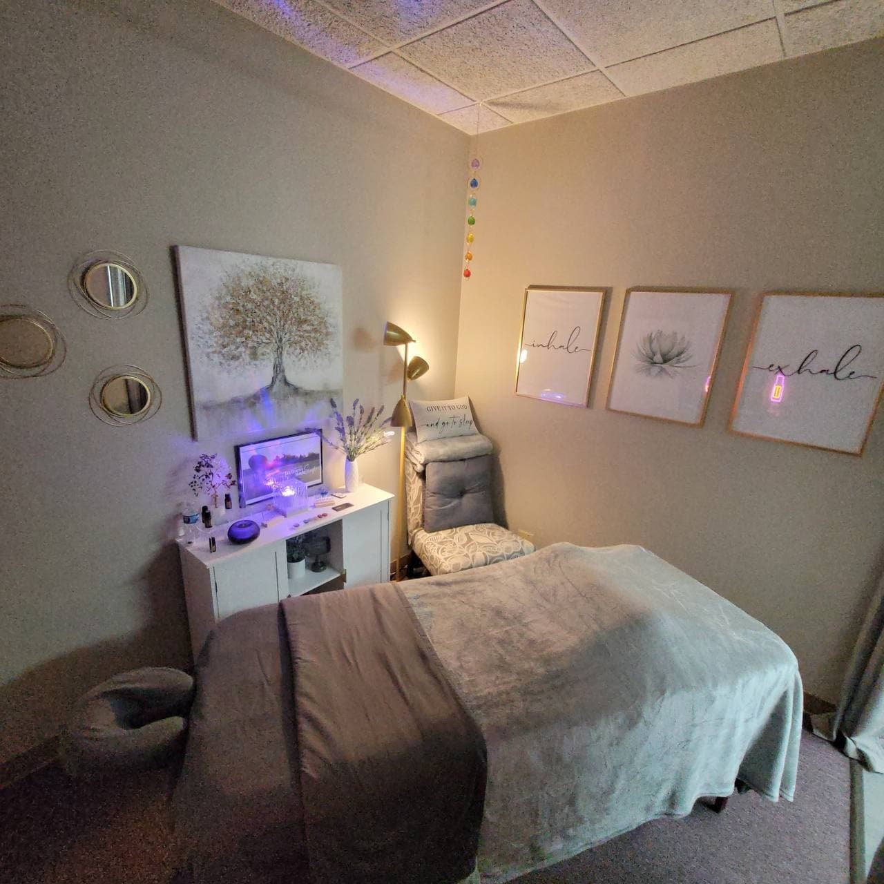 Angie's peaceful treatment room with soft lighting, a treatment table, diffuser glow, and grounding Reiki decor